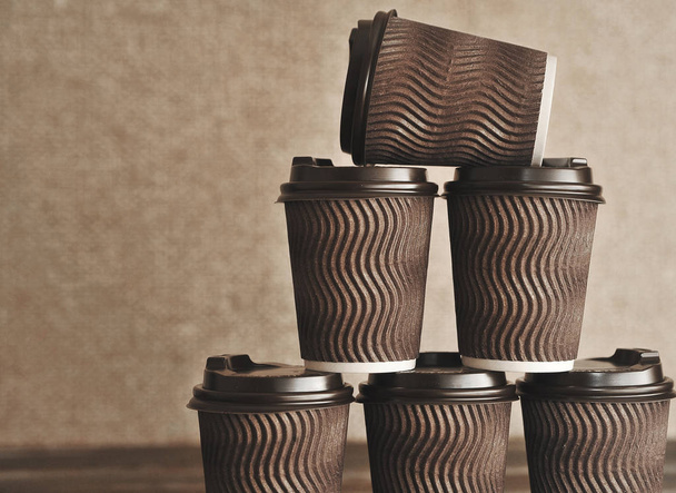Бумажные чашки для кофе на деревянном фоне
. - Фото, изображение