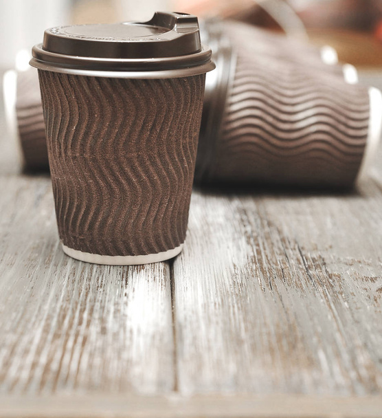 Tazas de papel marrón para café sobre fondo de madera
. - Foto, imagen