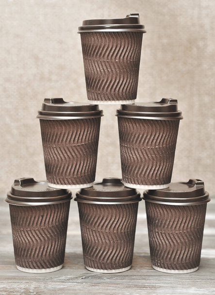 木製の背景にコーヒーのための茶色の紙コップ. - 写真・画像