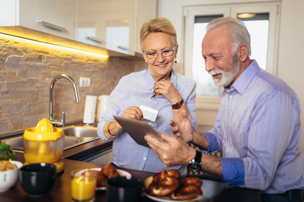 Modern senior couple shopping online with tablet and credit card - Foto, Bild