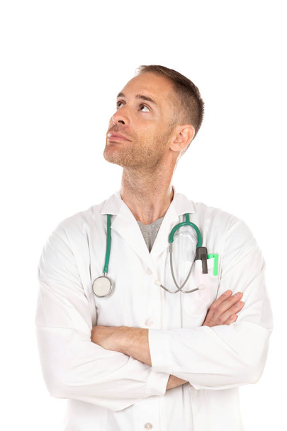 Giovane medico pensieroso che indossa un abito bianco isolato su uno sfondo bianco
 - Foto, immagini