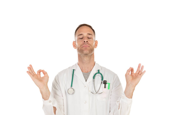 Young doctor practicing relaxation techniques to reduce stress isolated on a white background - Photo, Image