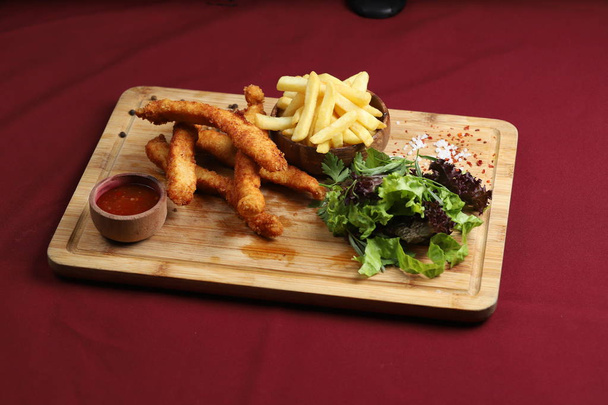 Fried cheese sticks with french fries, green salad and ketchup on wooden board. - Fotoğraf, Görsel