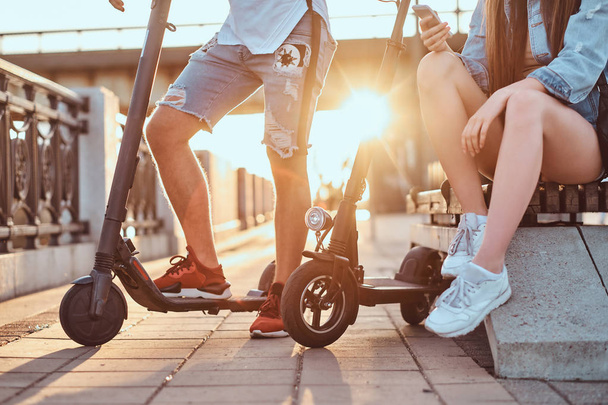 Un par de jóvenes se están relajando con sus scooters
 - Foto, Imagen