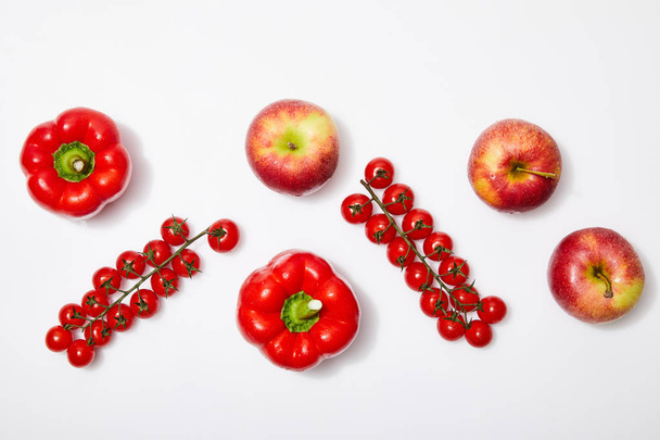вид сверху на красные яблоки и овощи на белом фоне
 - Фото, изображение
