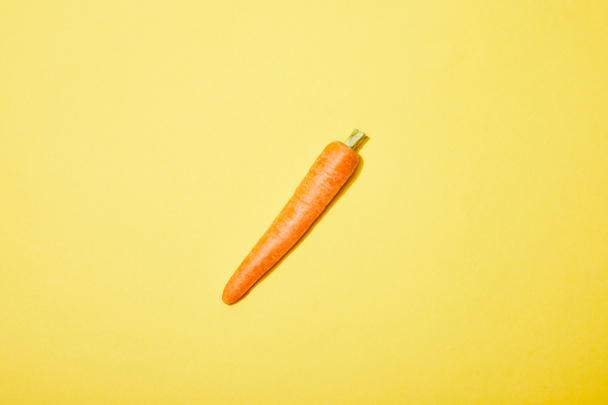 top view of organic carrot on yellow background - Foto, Imagem