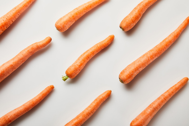flat lay with fresh carrots on white background - Fotó, kép