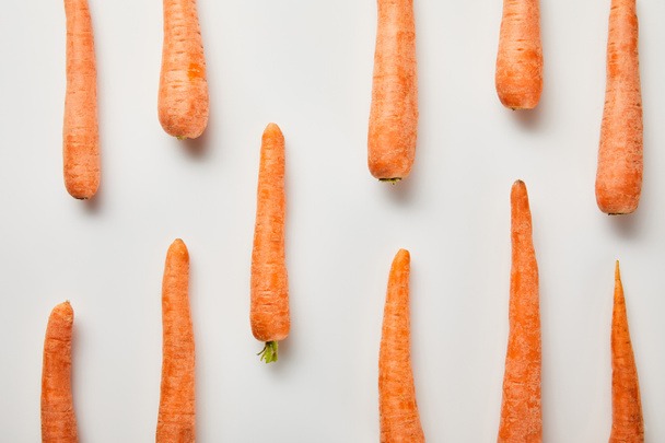 flat lay with fresh carrots on white background - Foto, Imagem