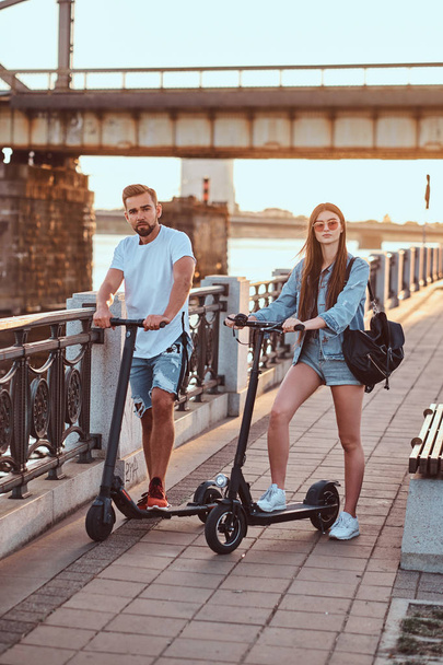 Genç çift, elektro scooterların keyfini çıkarıyor. - Fotoğraf, Görsel