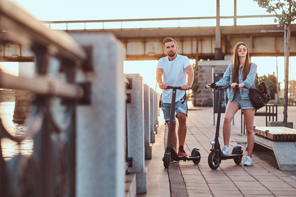 Giovane coppia sta godendo electro scooter equitazione
 - Foto, immagini