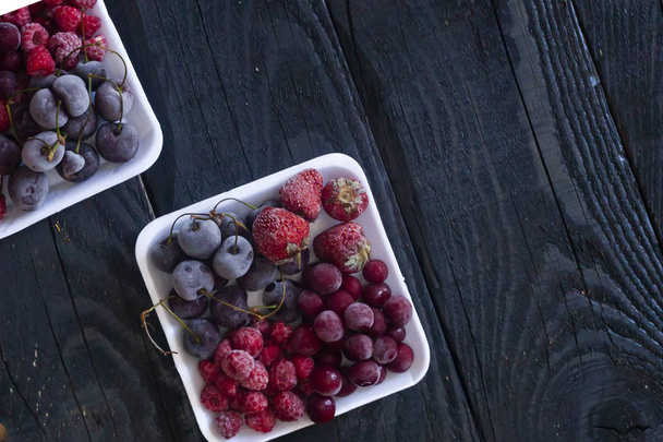 Homemade fresh frozen fruits. Healthy sweet dessert on dark rustic wood. - Фото, изображение