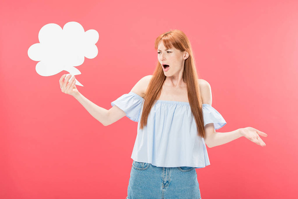 irritated redhead young woman holding empty thought bubble isolated on pink - Foto, immagini