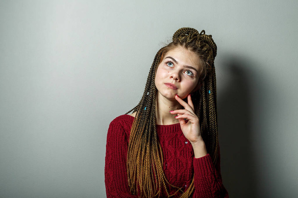 Close up shot of meditative emotional young pretty caucasian teenage girl with african braids and problem skin and in maroon sweater. - Φωτογραφία, εικόνα