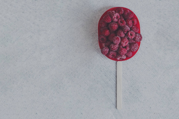 Frozen sweet raspberries with a stick. Summer food - Foto, Imagem