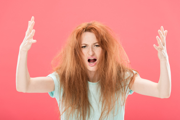 pelirroja enojada con el pelo enredado agitando las manos aisladas en rosa
 - Foto, Imagen