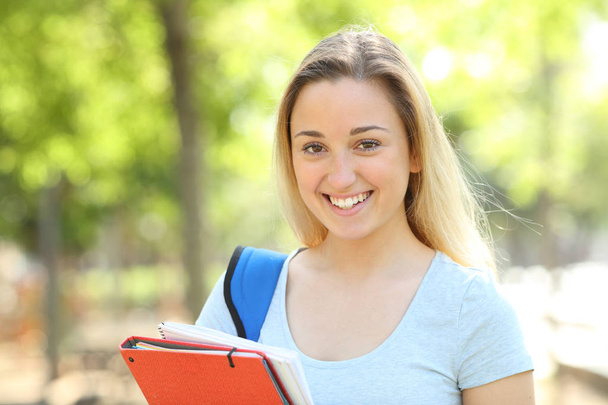 Happy teenage student looking at camera in a park - Фото, изображение