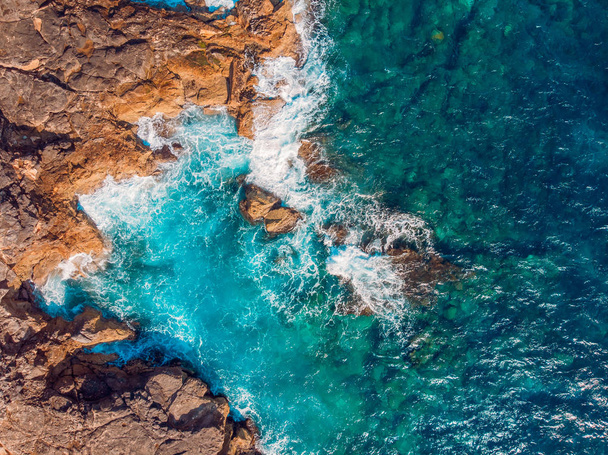 Vue de dessus Mer bleue azur avec des vagues battant sur la plage et les rochers. Photo aérienne
. - Photo, image