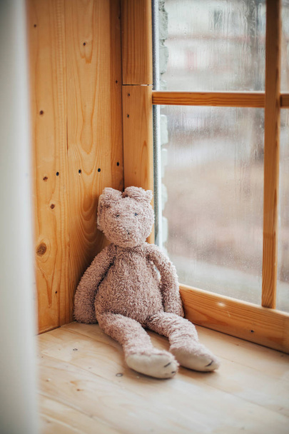 Кроличья игрушка на деревянном подоконнике дома
 - Фото, изображение