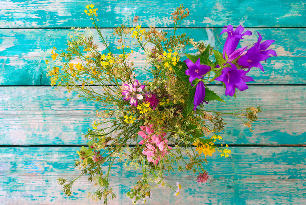 ヴィンテージ木製のテーブルに野生の花の花束 - 写真・画像