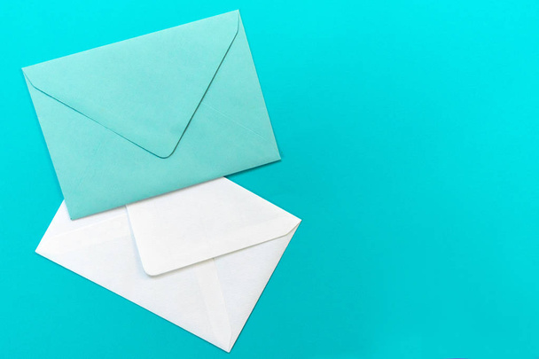 Envelopes azuis e brancos são isolados em um fundo azul claro. Conceito cartão de saudação.
. - Foto, Imagem
