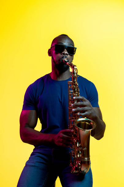 Fiatal afro-amerikai jazz-zenész játssza a szaxofon - Fotó, kép