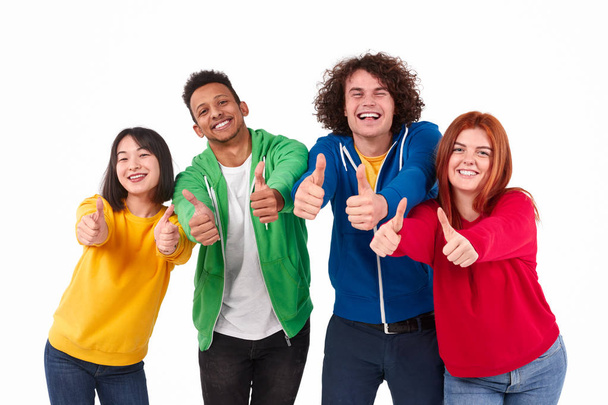 Cheerful diverse friends gesturing thumbs up - Photo, image