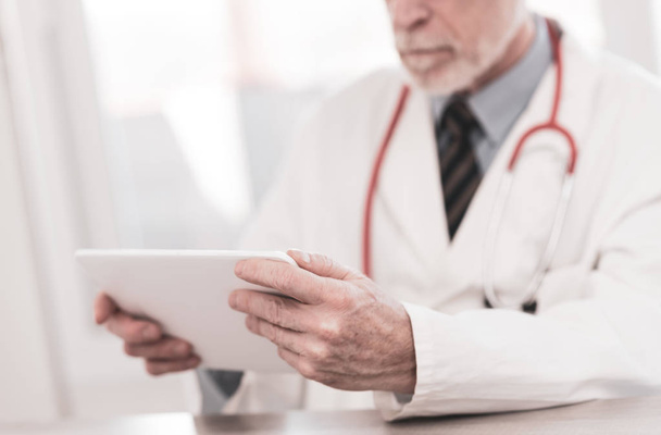 Чоловік лікар використовує цифровий планшет
 - Фото, зображення