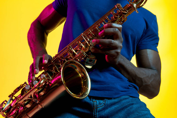 Молодой афро-американский джазовый музыкант играет на саксофоне
 - Фото, изображение