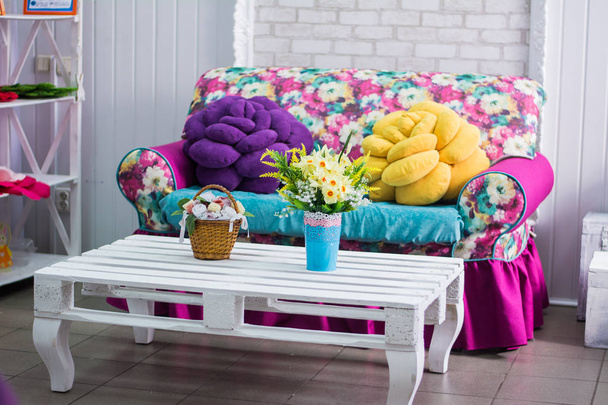 nterior szoba kanapé és asztal virágok fehér rózsaszín - Fotó, kép