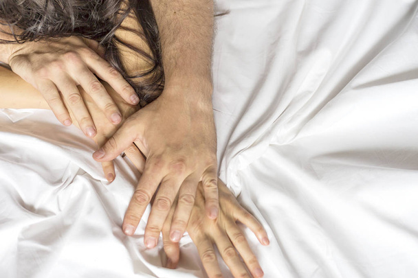 Fechar as mãos de um casal fazendo sexo em uma cama
 - Foto, Imagem
