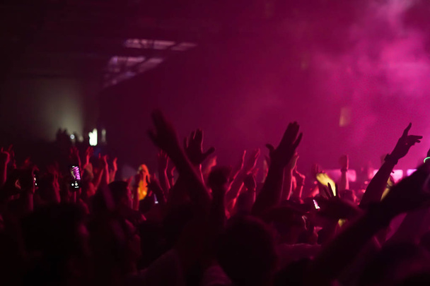 σιλουέτες των συναυλιών πλήθος μπροστά από φωτεινά φώτα σκηνής - Φωτογραφία, εικόνα