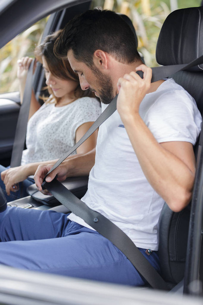 donna e uomo in macchina indossano una cintura di sicurezza
 - Foto, immagini