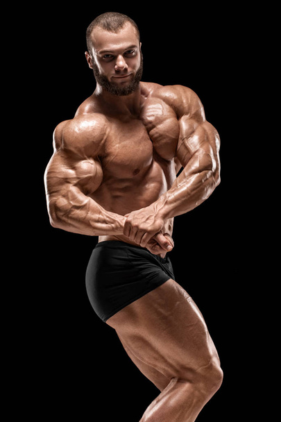 Homem musculoso mostrando músculos isolados no fundo preto. Forte masculino nu torso abs
 - Foto, Imagem