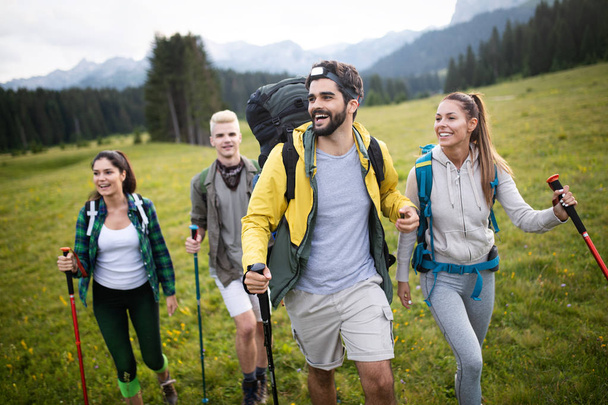 Group of friends on a mountain. Young people on mountain hike - 写真・画像
