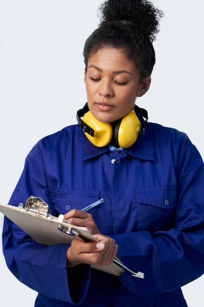 Studio Shot Of Female Engineer With Clipboard And Spanner Agains - Photo, Image