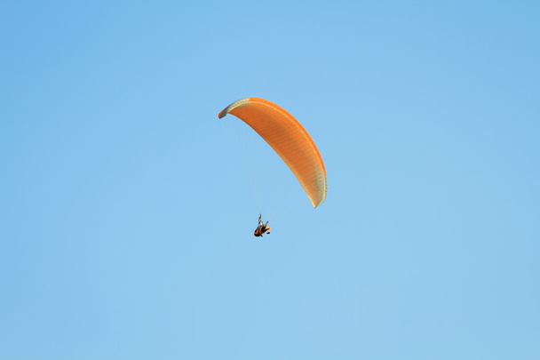 Paragliding against clear blue sky - Photo, Image