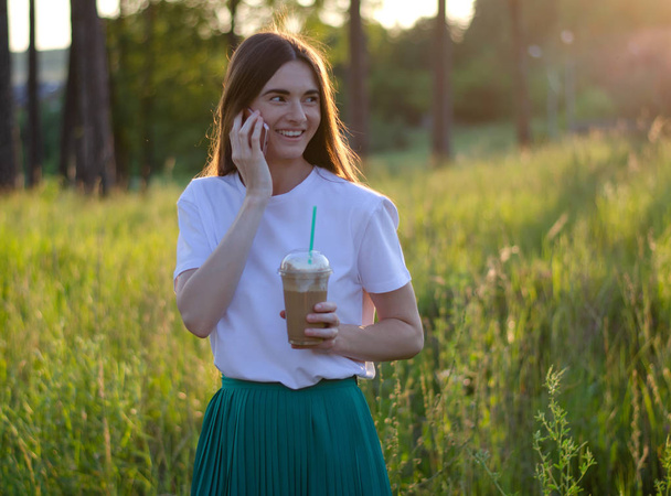 A young girl with a coffee cocktail. Summer image. - Фото, изображение