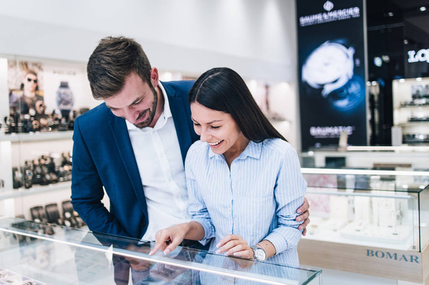 Beautiful couple enjoying in shopping at modern jewelry store.  - 写真・画像