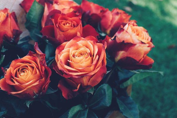 Ανθοδέσμη όμορφη μοναδική κόκκινη, πορτοκάλι και ροδάκινο χρώματα τριαντάφυλλα στο φυσικό υπόβαθρο. - Φωτογραφία, εικόνα