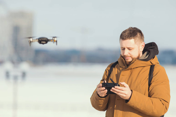 ein Mann mit einer Fernbedienung für die Drohne - Steuerung des Quadrokopterflugs - Foto, Bild