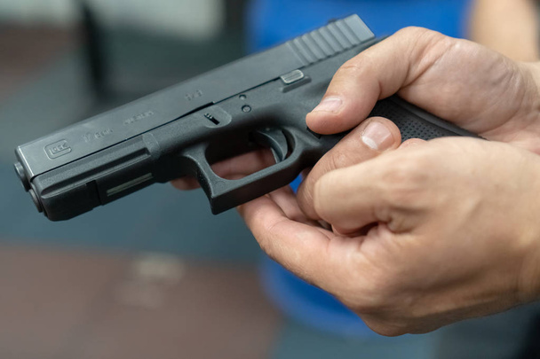eine Hand eines Mannes, der am Schießstand das Schießen mit einem Glock-Pistolenmodell übt. Handfeuerwaffe Glock - Foto, Bild