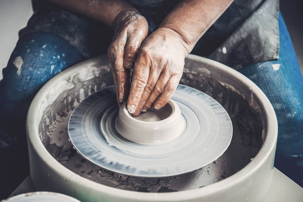 Maestro en la rueda de alfarero hace platos de barro. Lugar del taller
 - Foto, Imagen