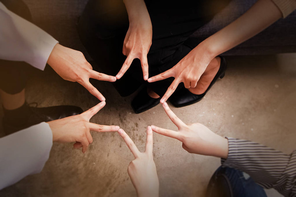 Em foco seletivo de dedos humanos tocar juntos, fazendo forma de estrela, sinal e símbolo de confiança, unidade, colaborador, trabalho em equipe, luz embaçada ao redor, efeito de filtro de vinheta
 - Foto, Imagem