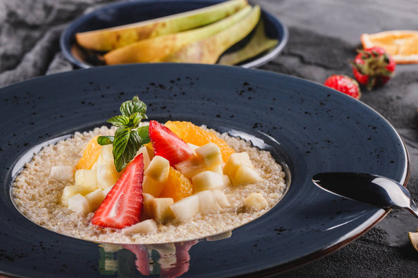 Kvinoa puuroa hedelmillä, mansikoilla, päärynällä, banaanilla ja kookoksella
 - Valokuva, kuva
