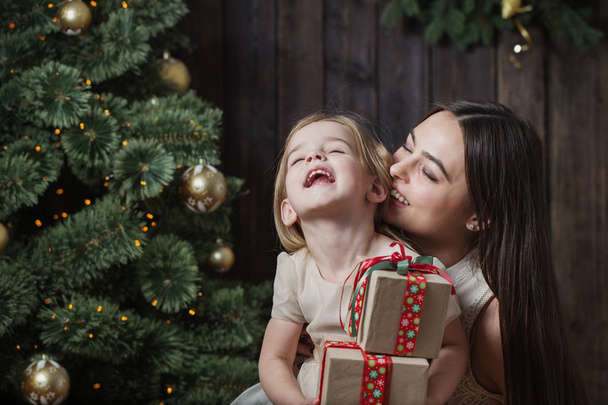 μητέρα και κόρη στο χριστουγεννιάτικο δέντρο σε ξύλινο φόντο - Φωτογραφία, εικόνα