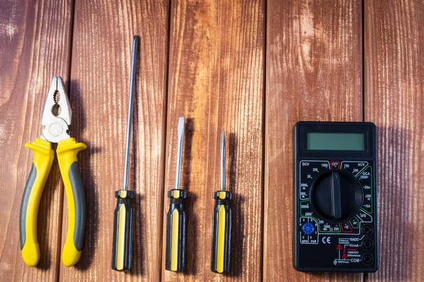 Een set van tools voor de elektricien op een houten achtergrond. - Foto, afbeelding