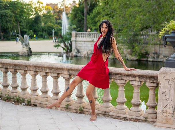 Ladyboy tattooed transgender model is dancing in the green park - Photo, Image