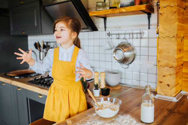 Little happy girl playing around in the kitchen. - Fotoğraf, Görsel