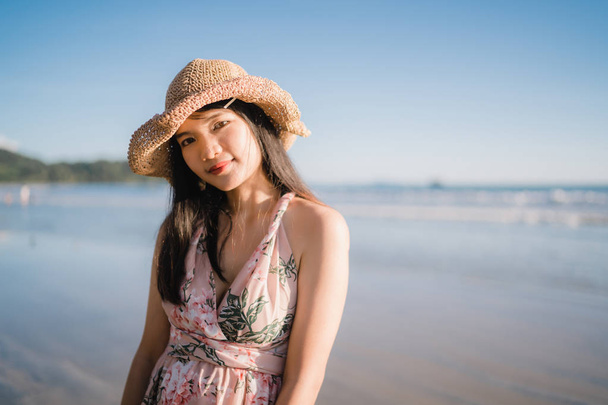 Młody Asian kobieta uczucie szczęśliwy na plaży, piękne kobiece szczęśliwy relaks uśmiechnięta zabawa na plaży w pobliżu morza, gdy zachód słońca wieczorem. Lifestyle kobiet podróży na plaży koncepcji. - Zdjęcie, obraz