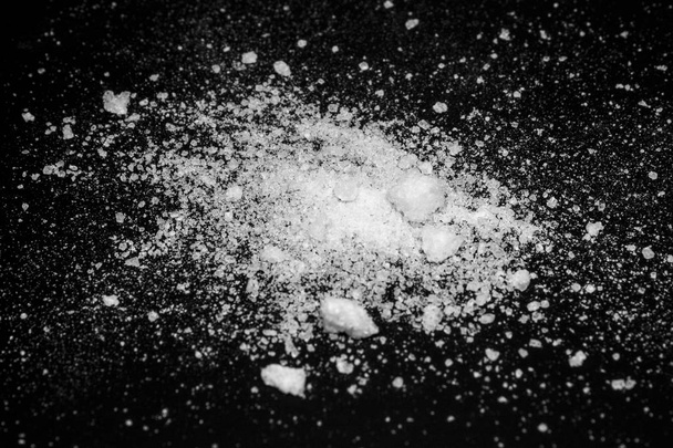 polvo cristalino blanco sobre un fondo negro. polvo de azúcar
 - Foto, imagen